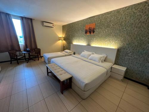 拿笃Fajar Hotel的酒店客房设有两张床和一张桌子。