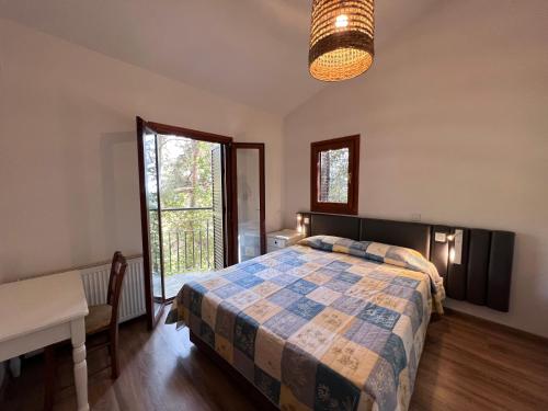 普拉特斯POED Residences的一间卧室配有一张床、一张桌子和一个窗户。