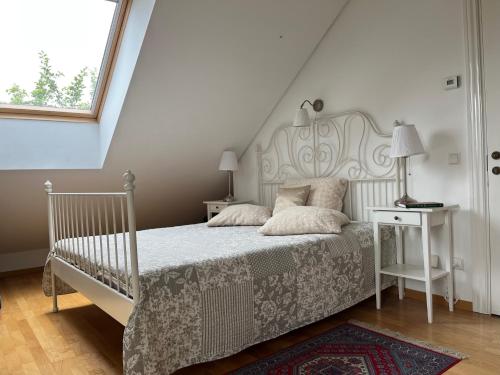 特拉凯Villa Sofia Boutique Trakai的卧室配有一张带白色床架和窗户的床