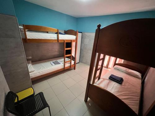 滨河托雷斯ALBERGUE CASA MARIELA solo peregrinos con credenciales的小房间设有两张双层床和椅子