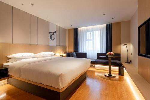 哈尔滨哈尔滨城市中心万枫酒店的一间带大床的卧室和一间客厅