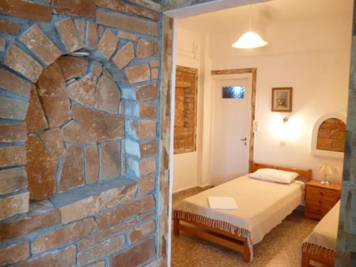 伊奥斯乔拉Vasilis Place Ιos的一间卧室设有石墙,配有一张床