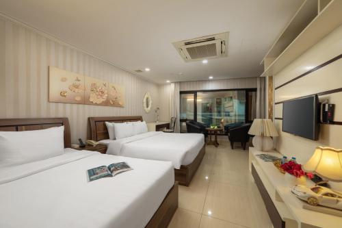 河内HALO HANOI HOTEL的酒店客房设有两张床和电视。