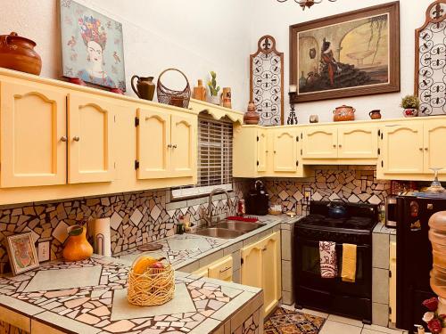 罗萨里托Cozy Apartment Villas的厨房配有黄色橱柜和炉灶烤箱