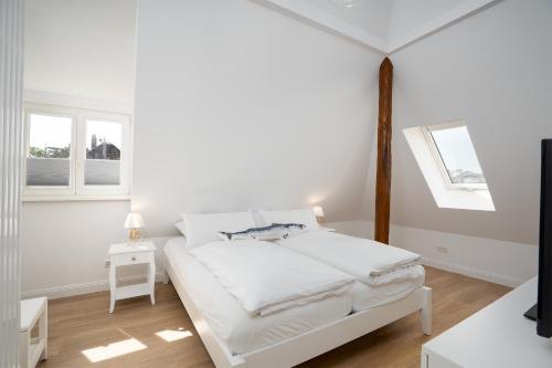 蒂门多弗施特兰德KUR18 Ferienwohnung Baltic Deck的一间白色卧室,配有床和2个窗户
