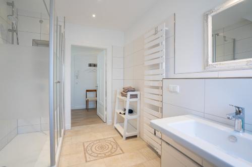 蒂门多弗施特兰德KUR18 Ferienwohnung Baltic Deck的白色的浴室设有水槽和镜子