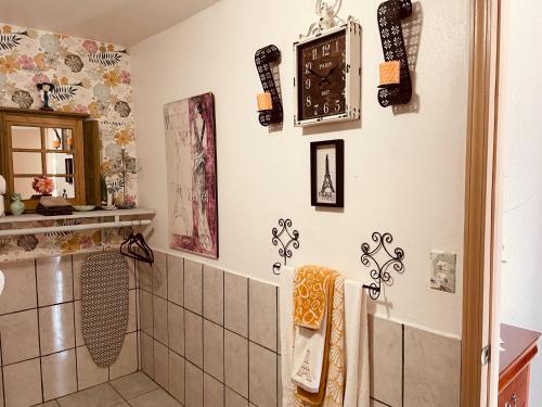 罗萨里托Cozy Apartment Villas的带淋浴的浴室和墙上的时钟