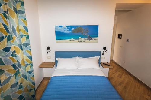 朱利亚诺瓦Casale Ferrantino的卧室配有蓝色的床和墙上的绘画作品
