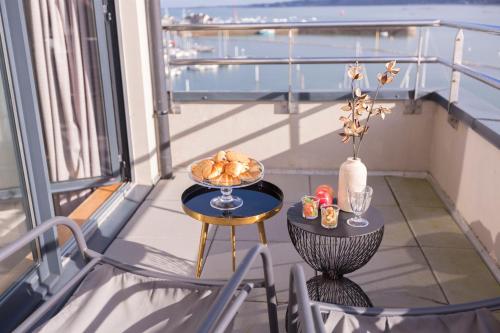 佩罗斯-吉雷克Le Nautica Hôtel的阳台配有餐桌,上面放着一碗食物
