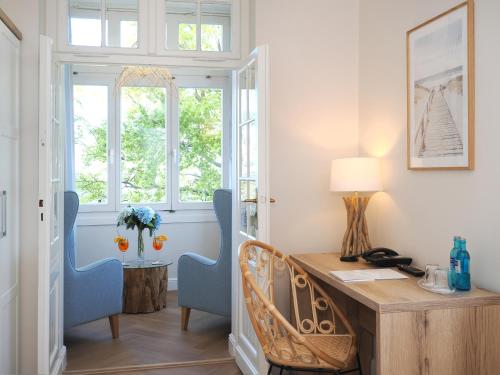 黑灵斯多夫Strandvillen Heringsdorf的配有木制书桌和蓝色椅子的家庭办公室