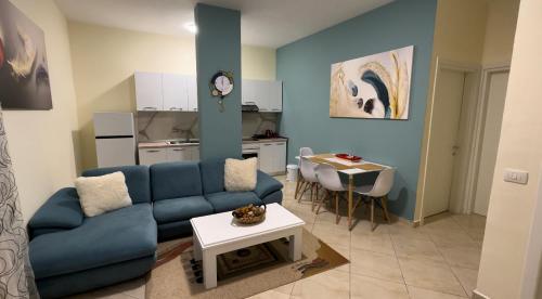 地拉那Villa Apartments S&F City Centre的客厅配有蓝色的沙发和桌子