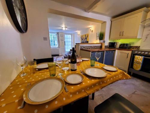 SarreCourt Cottage, 2 bed period house的厨房配有带盘子和酒杯的桌子