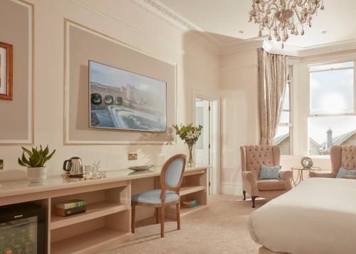 巴斯Bathen House Boutique Hotel的酒店客房设有一张床、一张书桌和一台电视机。