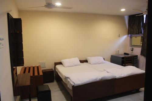 加尔各答Service Apartments, Park Street, Calcutta的一间小卧室,配有床和床头柜