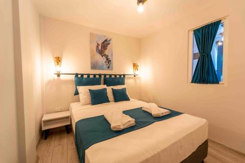 凯麦尔Kamkat Otel的一间卧室配有一张带蓝色枕头的大床