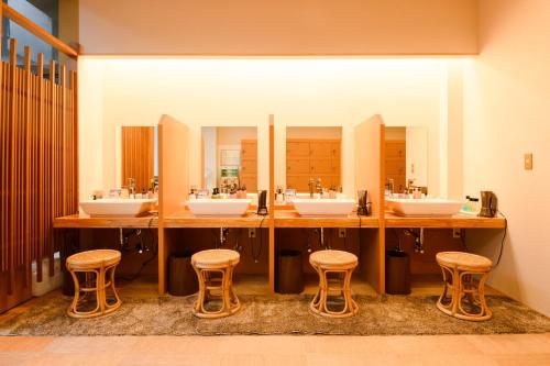 加贺Shirasagiyu Tawaraya的浴室设有4个水槽和3个凳子