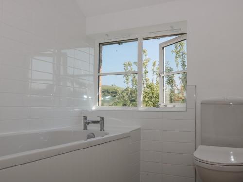 韦茅斯White Horse Cottage的白色的浴室设有水槽和卫生间。