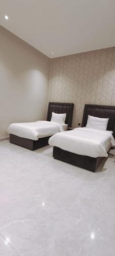 巴哈شاليهات أبيات الفندقية的配有2张床的带白色床单和枕头的客房
