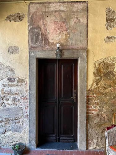 MasseranoBorgo Antico di Masserano tra laghi e monti的石头建筑中一扇黑色的砖墙门