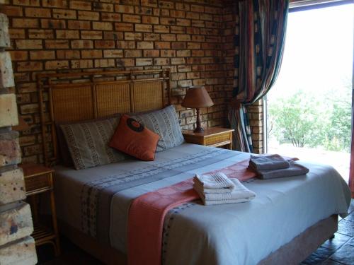 Maanhaarrand渴瀑布游客农场酒店的砖墙房间的一个床位