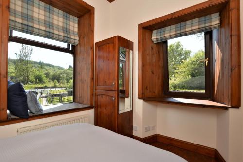 CairnbaanCairnbaan House的一间卧室设有一张床和两个窗户。
