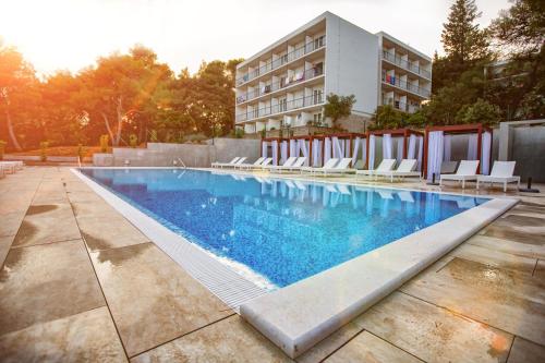 韦伯斯卡Labranda Senses Resort的一个带椅子的游泳池和一间酒店