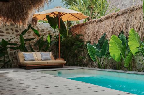 塞隆贝拉纳克Boni Beach Lombok Boutique Hotel的游泳池旁的遮阳伞和椅子
