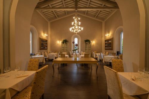 埃尔萨谷口村帕拉佐圣洛伦索Spa酒店的一间带桌椅和吊灯的用餐室