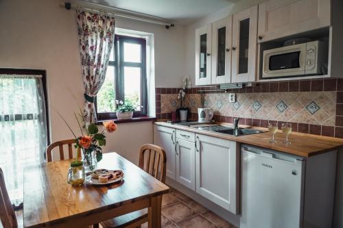 ČernínyPenzion Apartmány Hetlín的厨房配有白色橱柜、桌子和水槽。