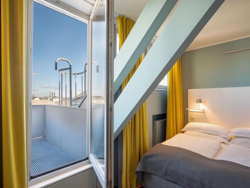 科隆科隆会展中心纽约人酒店的一间卧室设有一张床和一个大窗户