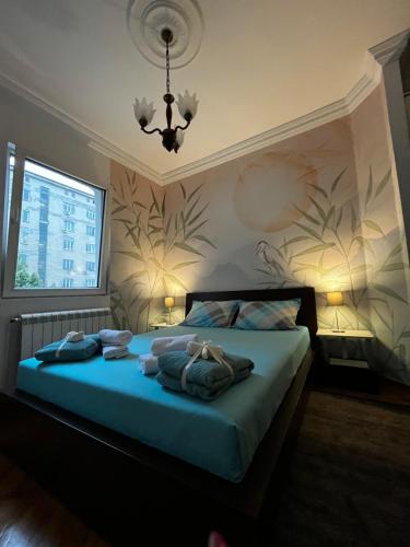 SajmišteApartman Sasha 1的一间卧室配有一张带蓝色床单和吊灯的床。