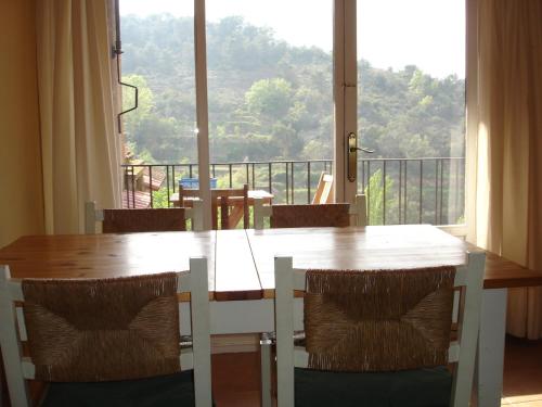 MuraAPARTAMENTS PUIG GILI的餐桌、椅子和大窗户