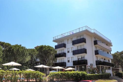 利尼亚诺萨比亚多罗伊甸酒店的带阳台和遮阳伞的白色建筑