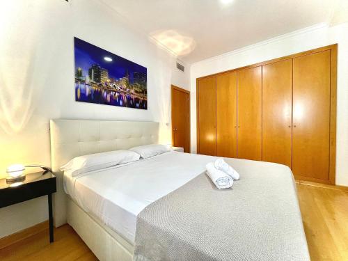 塞维利亚Luxury Duplex 200 M2 Terrace Parking StayInSeville的卧室配有一张床,墙上配有电视。