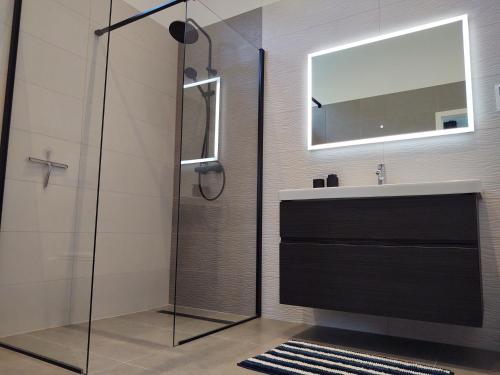 瓦拉日丁Open Space的一间带玻璃淋浴和水槽的浴室