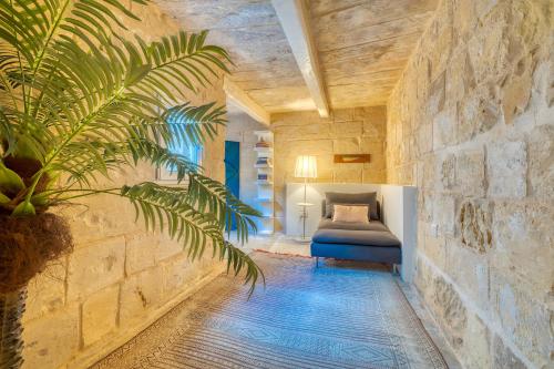 科斯皮夸Le Petit Voyage - CHILL OUT的卧室配有一张石墙床