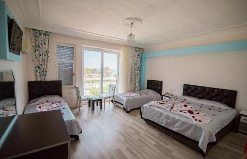 菲尼凯Deniz Hotel的一间卧室配有两张床和一张桌子