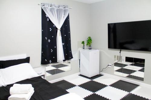 Lower SackvillePrivate bedrooms+free parking的一间配有电视的卧室,铺有黑白地板