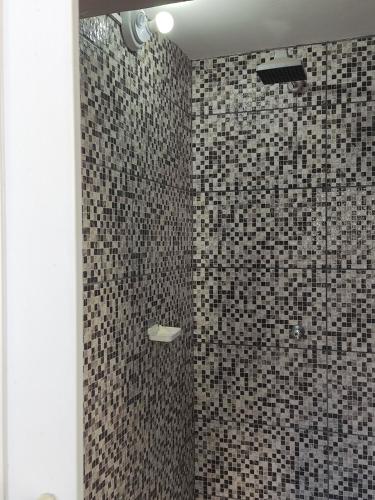 圣保罗Parada 86 Hostel的浴室铺有黑白瓷砖,设有淋浴。