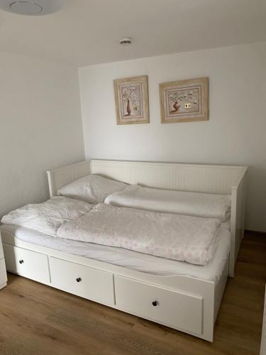 汉诺威Family & Friends Hannover 75m2, Messe的墙上有两张照片的房间的一张白色床