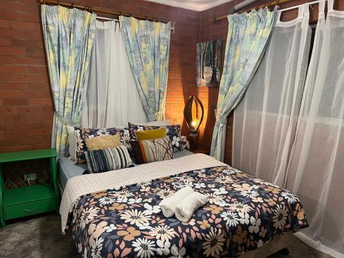 卡伦德拉XYL Pets Friendly Opened Spacious Seaside Boutique Guesthouse的一间卧室配有床、被子和窗帘