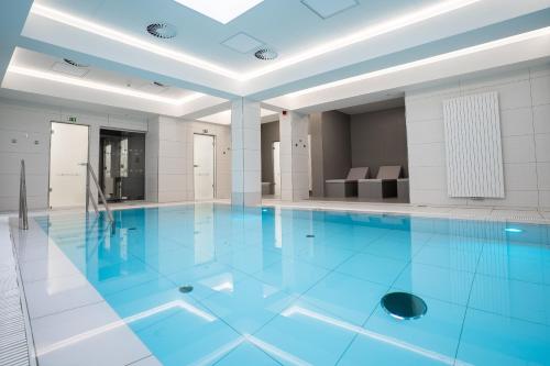 卡罗维发利Family Apartments by ASTORIA Hotel & Medical Spa的大楼内的一个蓝色海水游泳池