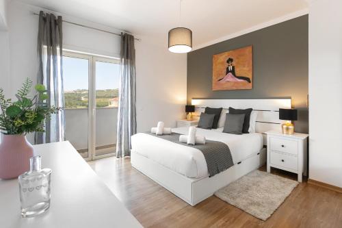 奥比多斯Óbidos Pool & Charm的卧室设有白色的床和大窗户