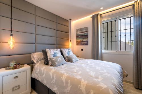 米哈斯科斯塔Lets in the Sun Casa del Cielo Apartment的卧室配有白色的床和窗户。