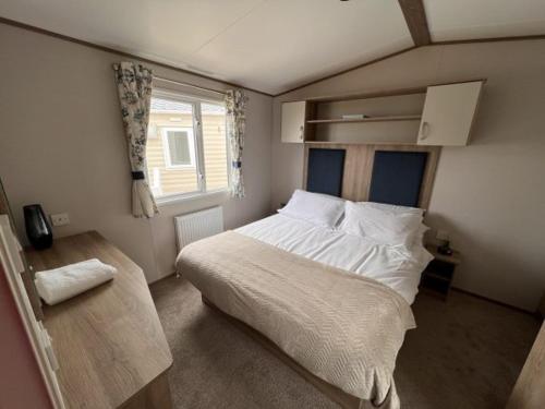 洛西茅斯Lolas Lodge的一间卧室设有一张大床和一个窗户。