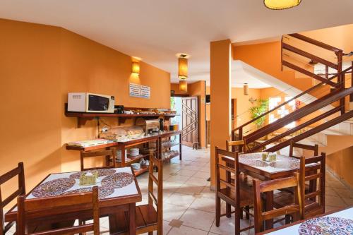乌巴图巴Pousada Recanto Montecarlo的一间带桌椅的餐厅,以及楼梯