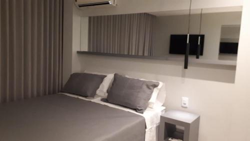 巴西利亚Flats Asa Norte CLN 110 by CentoEdez的一间卧室配有带两个枕头的床和电视