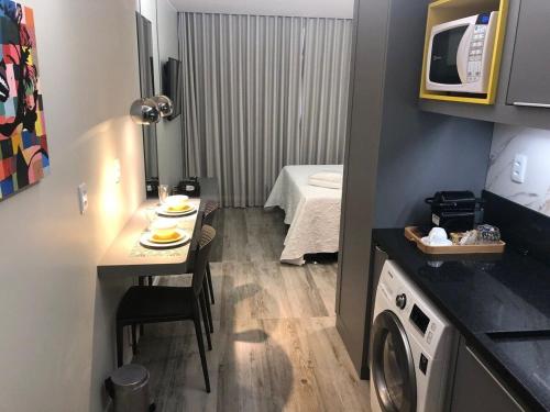 巴西利亚Flats Asa Norte CLN 110 by CentoEdez的小房间设有桌子和洗衣机