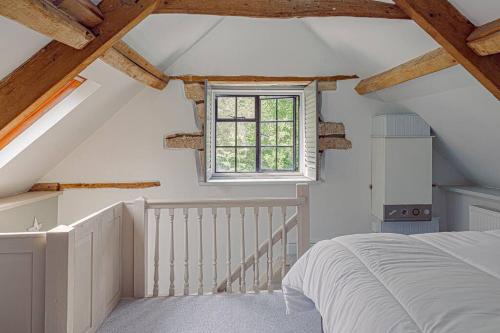 HarescombeMill House Cottage - Star Stay on The Cotswold Way的阁楼卧室设有床和窗户。