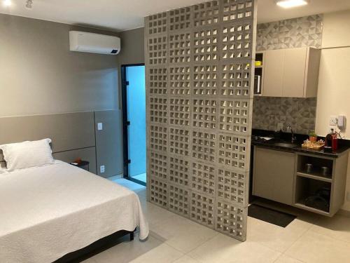 巴西利亚Flats Condomínio Park Ville by CentoEdez的一间卧室设有一张床,墙上设有厨房